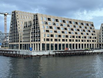 Buildings by sea against sky