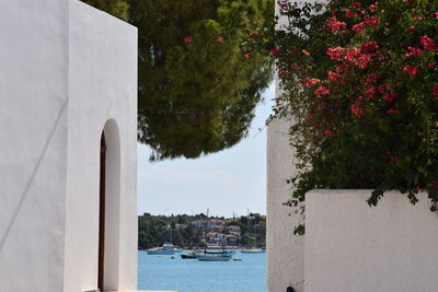 Scenic view of sea by buildings against sky