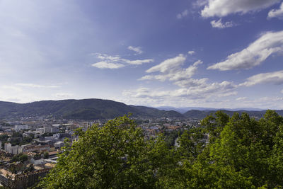 Trees and townscape against sky