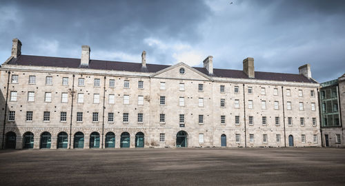 Facade of old building against cloudy sky