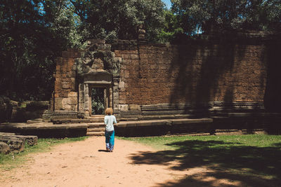 Rear view of woman walking against temple