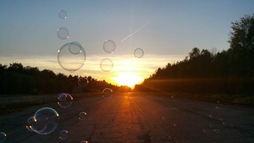 Cars parked on road at sunset