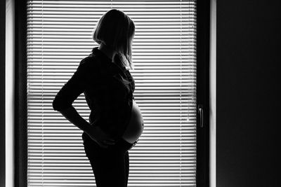 Pregnant woman standing by door