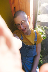 Non-binary person with eyeglasses taking selfie