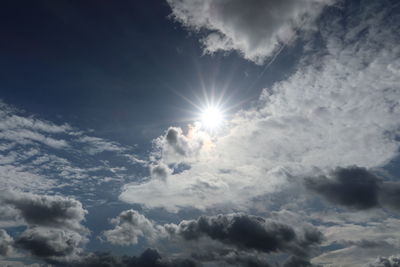 Low angle view of bright sun in sky