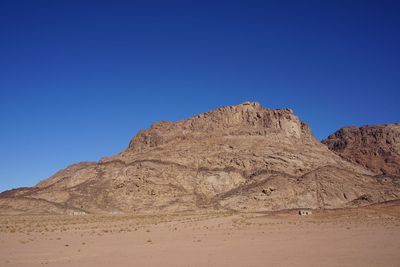 Low angle view of rock formations against clear blue sky