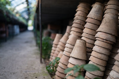 Closeup of stacks of old used weathered terra cotta flower pots in gardening shed