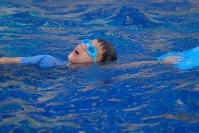 Portrait of girl lying in swimming pool