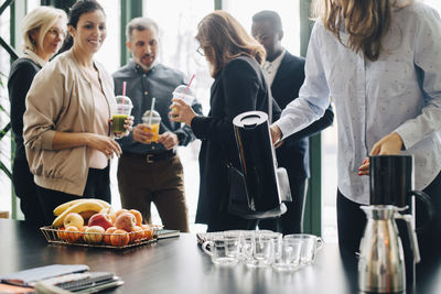 Business people having drinks and fruits during conference in office