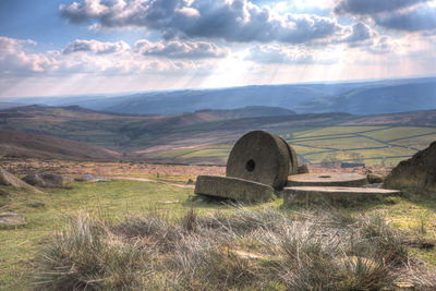 Scenic view of field and mountains against sky