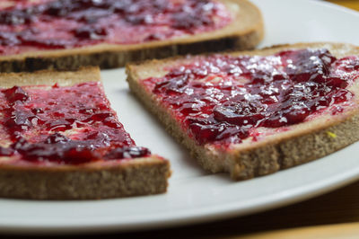 Close-up of brown breads with cherry jam on plate