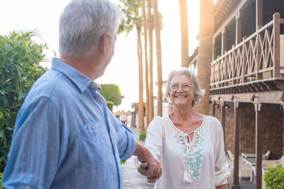 Side view of couple standing against wall