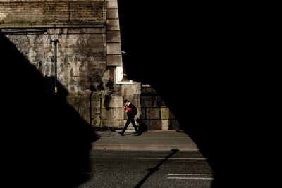 Rear view of man walking on street in city