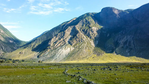 Scenic view of field and mountains against sky