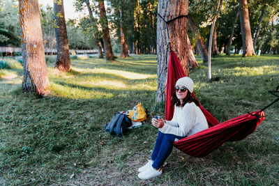 Woman lying on hammock in forest