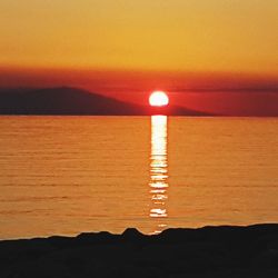 Scenic view of sea against romantic sky at sunset