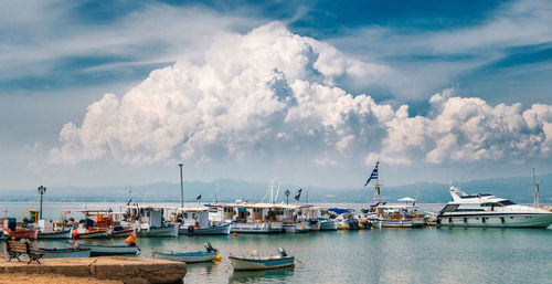 Sailboats moored at harbor against sky