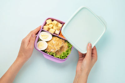 Midsection of woman holding bowl against white background