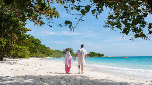 Rear view of woman walking at beach