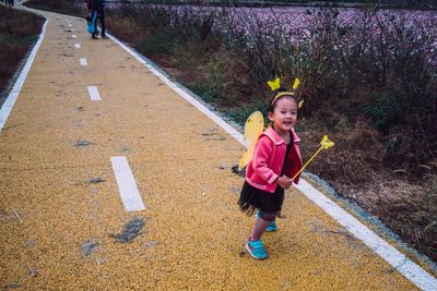 Full length portrait of girl standing against plants