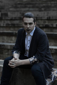 Portrait of young man with eyes closed sitting on steps 