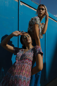 Low angle view of woman standing against wall