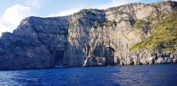 Panoramic shot of rock by sea against sky
