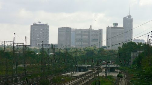 Railroad tracks amidst buildings in city against sky