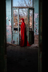 Woman standing by window in abandoned building