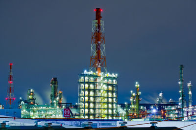 Low angle view of illuminated crane against sky at night