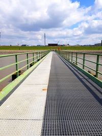 Footbridge over sea against sky