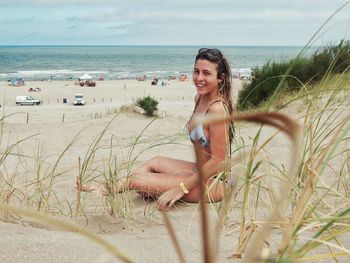 Young woman on beach against sky