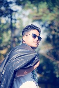 Portrait of young man wearing sunglasses standing outdoors