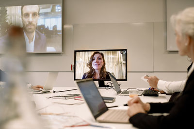 Male and female professionals planning strategy in web conference meeting at workplace