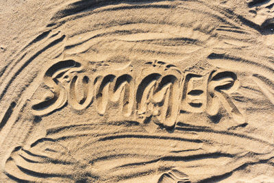 High angle view of text on sand