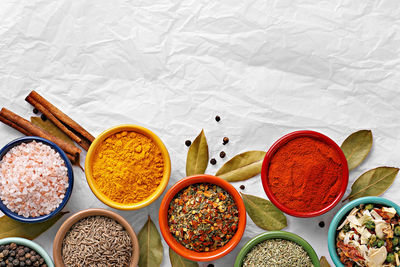 Directly above shot of spices in bowl on white paper