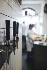 Equipment mounted on wall against chefs working in restaurant kitchen