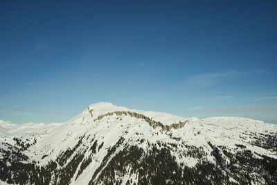 Scenic view of snowcapped mountains against blue sky