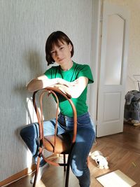 Young woman sitting on chair at home