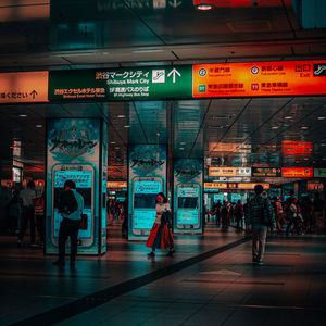 People walking on illuminated city at night