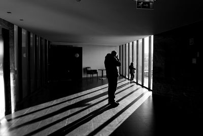 Silhouette people walking in corridor