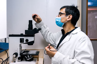 Male scientist using microscopy in laboratory