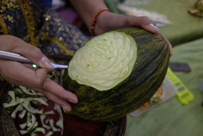 Cropped hands of woman carving on food