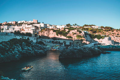 High angle view of buildings by sea against clear sky