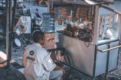 Rear view of man working at market stall