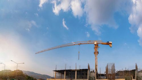 Low angle view of crane against sky