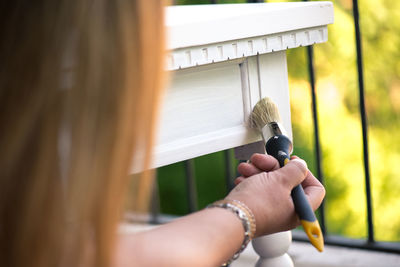 Cropped image of woman painting furniture