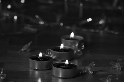 Close-up of lit tea light candles on table