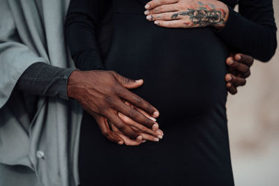 Midsection of couple holding hands