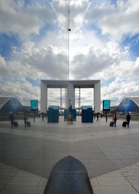 People at modern office building against sky